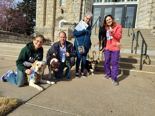 Group of dogs and dog owners holding certificates and ribbons
